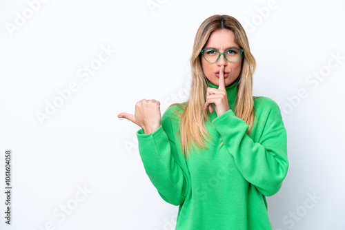 Young Uruguayan woman isolated on white background pointing to the side and doing silence gesture photo