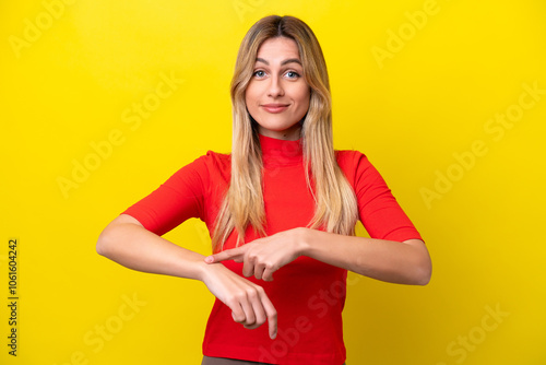 Young Uruguayan woman isolated on yellow background making the gesture of being late