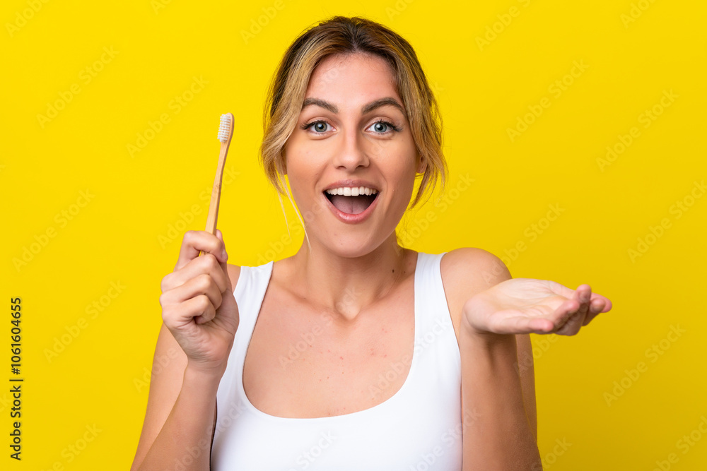 Young Uruguayan woman brushing teeth isolated on yellow background with shocked facial expression Young Uruguayan woman brushing teeth isolated on yellow background with shocked facial expression