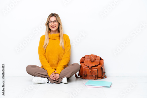 Uruguayan student woman sitting one the floor isolated on white background laughing