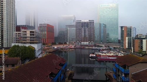 Aerial video over Blackwall Basin waterside and foggy Canary Wharf skyline  photo