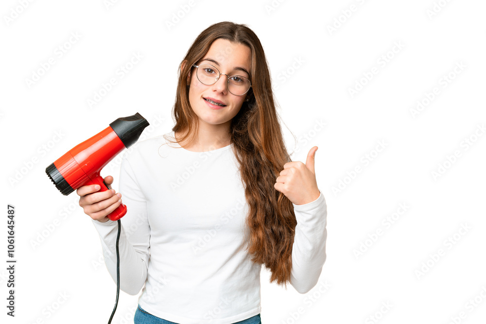 Teenager girl holding a hairdryer over isolated chroma key background pointing to the side to present a product Teenager girl holding a hairdryer over isolated chroma key background pointing to the side to present a product