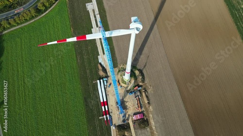 Wind power plant under construction. Aerial view of wind energy construction site on agricultural farmland.