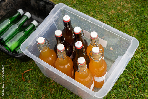 Freshly squeezed apple juice or hard cider in pop top or swing top bottles, outdoors at an orchard Apple Day event in Fall or Autumn photo