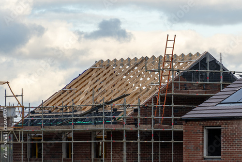 Roofing a property on a building site. New build housing in the suburbs. Construction concept.