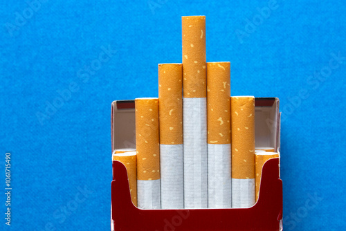top view of an opened packet with cigarettes on blue background