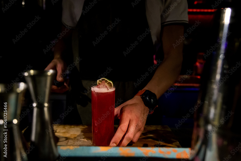 Obraz premium Bartender mixing alcoholic cocktail drink with ice cubes. Bartender hands pouring beverage. Man fingers. Cocktail glass with ice on top. Pouring soda in a cocktail glass. Ring man hands