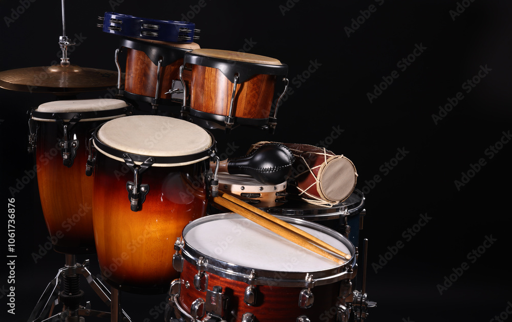 Different drums on a black background, percussion musical instruments Different drums on a black background, percussion musical instruments