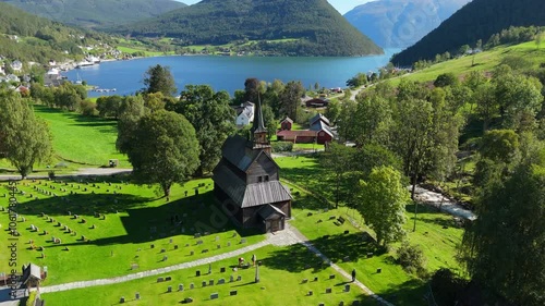 Kaupanger stave church, Norway, green grass and blue fjord in the background, aerial footage, drone video photo