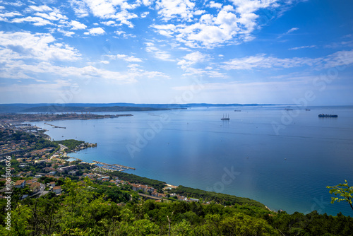 A large, expansive body of water appears, with a city located in the distance