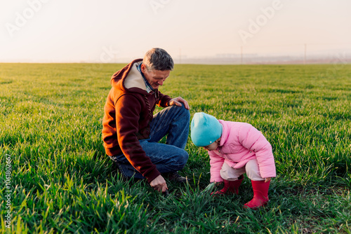 Grandfather and granddaughter in the field with sunlight