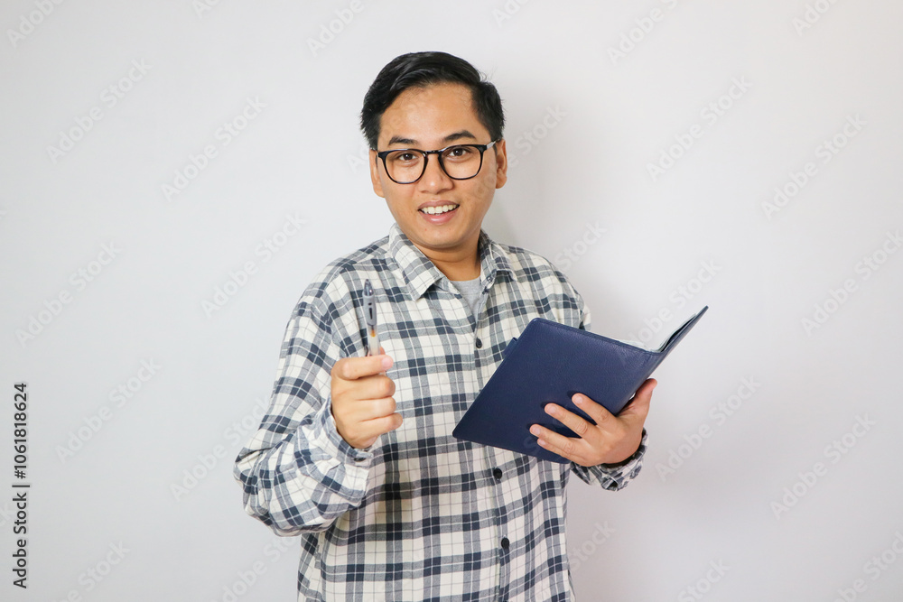 Portrait young man wear glasses casual shirt holding the books happy smile point finger at you isolated. Portrait young man wear glasses casual shirt holding the books happy smile point finger at you isolated.