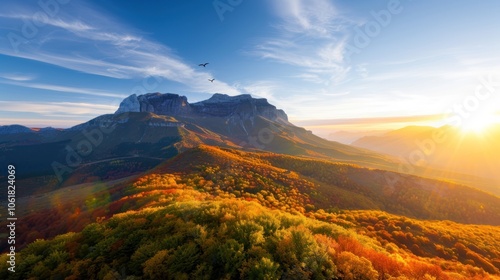 A stunning landscape captures vibrant autumn colors on a mountain, illuminated by a warm sunset and framed by a clear sky.
