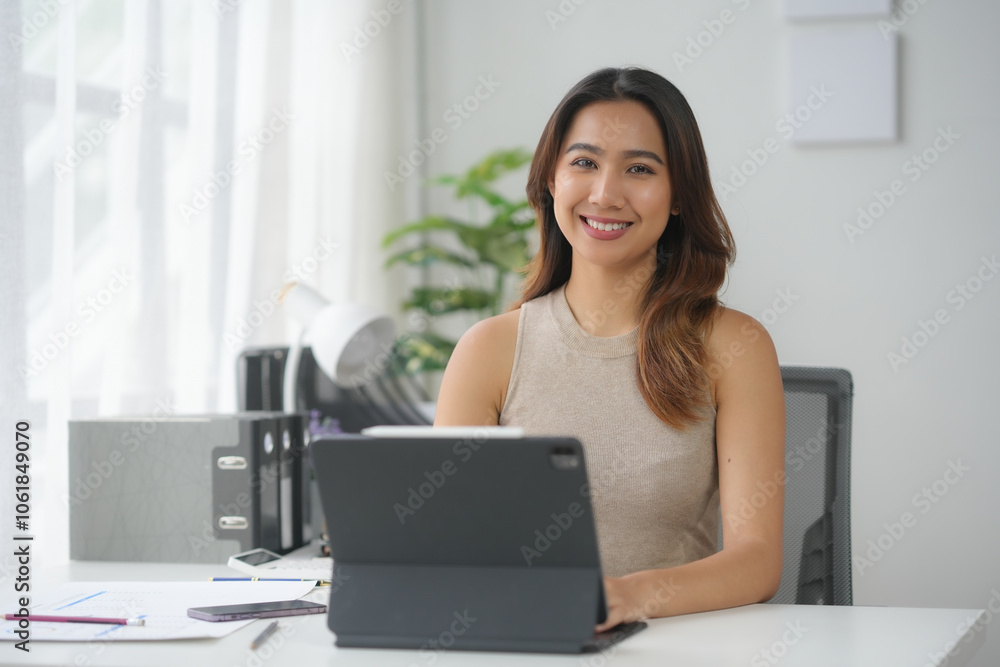 Confident woman working on a tablet at a modern office desk. Bright and productive workspace with a cheerful atmosphere. Confident woman working on a tablet at a modern office desk. Bright and productive workspace with a cheerful atmosphere.