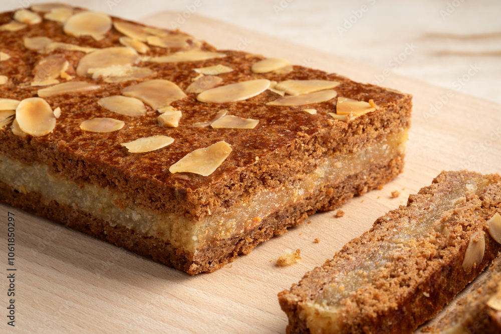 Piece of typical Dutch treat called gevulde speculaas and slices to be served at Sinterklaas evening on a cutting board close up Piece of typical Dutch treat called gevulde speculaas and slices to be served at Sinterklaas evening on a cutting board close up