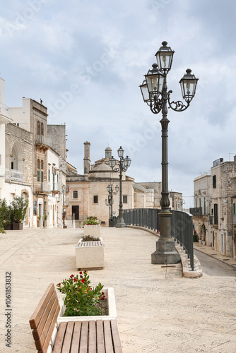 Ancient southern Italian white town with old houses,  church and lanterns, Cisternino, Puglia, Italy photo