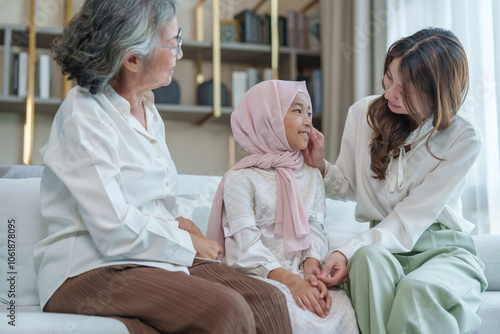 A child girl wear hijab with mother visit her grandma at home,happy asian family in the living room