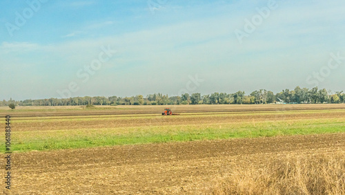 Agricultural fields with young green shoots of grain crops and plowed field without sowing. With trees in the background on the hills. Fallow concept. Alternation.