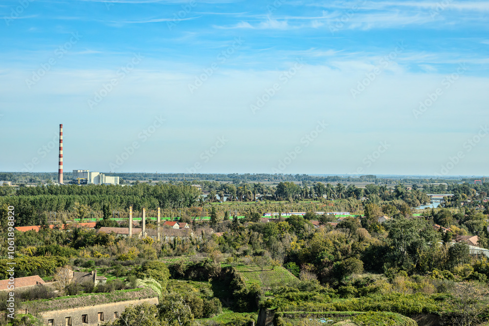 Fototapeta premium Agricultural fields with young green shoots of grain crops and plowed field without sowing. With trees in the background on the hills. Fallow concept. Alternation.