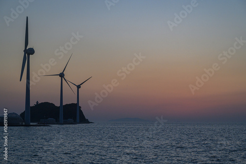 on the beach with a wind turbine and an island in the background taken at the tando island port of Korea. photo