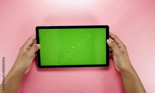 person holding tablet pc with the green screen