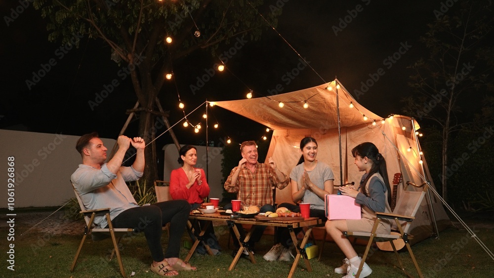Family together celebrate anniversary in garden. Senior give gift to granddaughter. Outdoor camping activity to relax with relatives, spend time with multigeneration cross generation gap. Divergence. Family together celebrate anniversary in garden. Senior give gift to granddaughter. Outdoor camping activity to relax with relatives, spend time with multigeneration cross generation gap. Divergence.