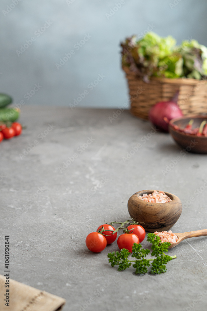 Fresh vegetables and greens lie on a gray table. Space for text Fresh vegetables and greens lie on a gray table. Space for text