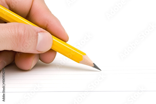 Hand holding a sharpened yellow pencil poised over lined paper, symbolizing writing, creativity, and education