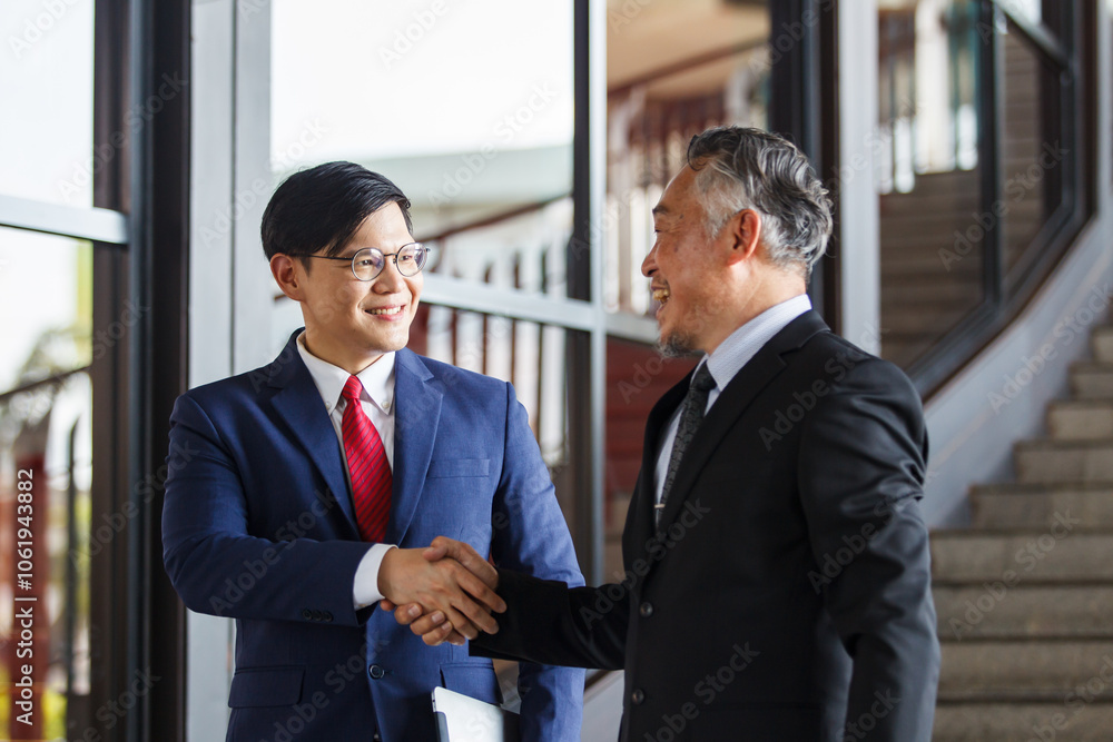 Two Asian businesspeople having a business discussion in the office building. Two Asian businesspeople having a business discussion in the office building.