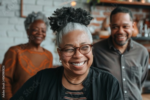 Portrait of happy senior African American woman in eyeglasses looking at camera with friends in background