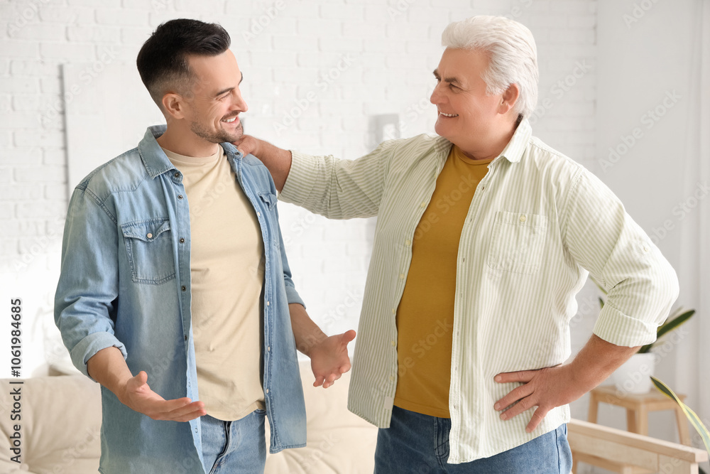 Obraz premium Mature man chatting with his son at home