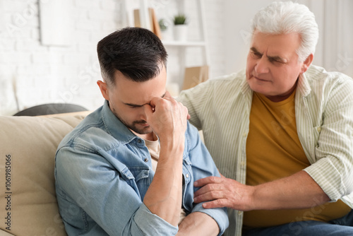 Mature man calming his upset son at home