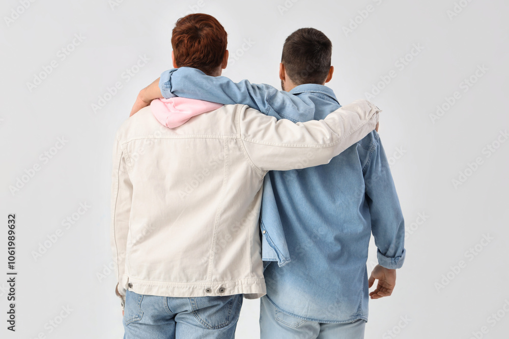 Male friends hugging on white background, back view Male friends hugging on white background, back view