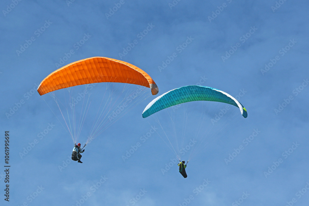 Paragliders flying in a blue sky Paragliders flying in a blue sky