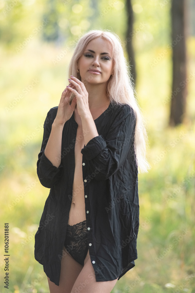 Portrait of a beautiful young blonde girl in a black shirt in the forest. Portrait of a beautiful young blonde girl in a black shirt in the forest.
