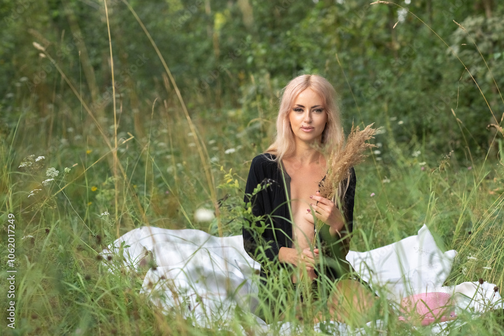 Portrait of a beautiful young blonde girl in a black shirt in the forest. Portrait of a beautiful young blonde girl in a black shirt in the forest.