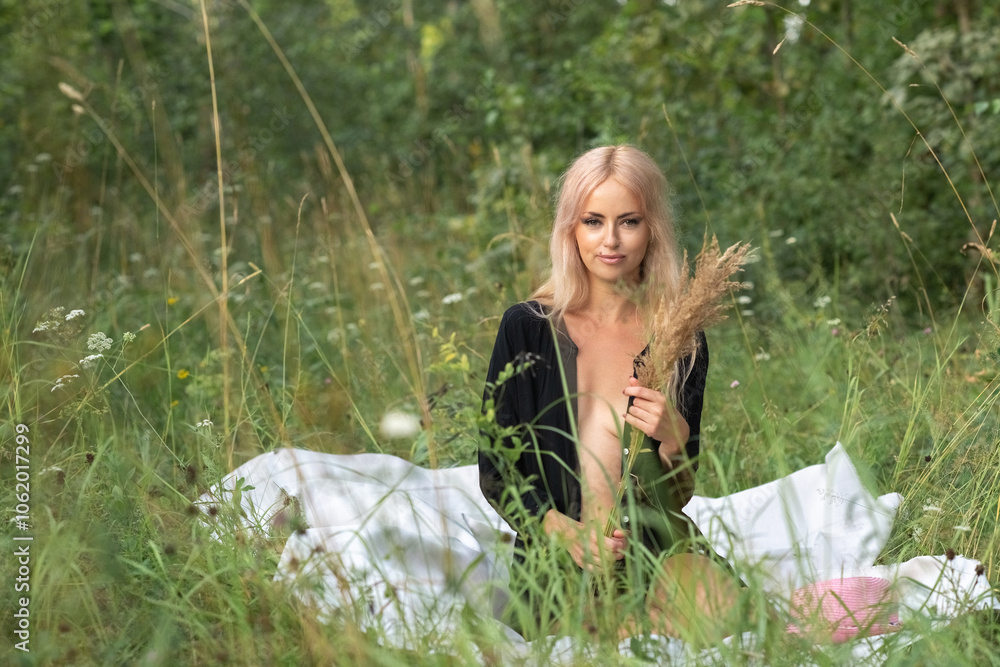 Portrait of a beautiful young blonde girl in a black shirt in the forest. Portrait of a beautiful young blonde girl in a black shirt in the forest.