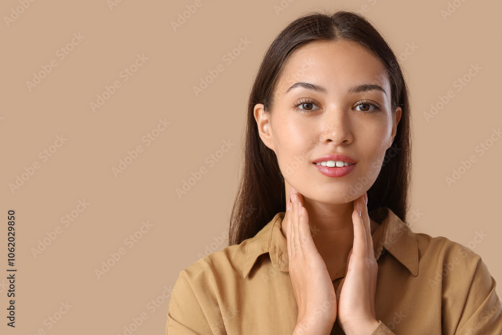 Young Asian woman self-examining thyroid gland on beige background, closeup Young Asian woman self-examining thyroid gland on beige background, closeup