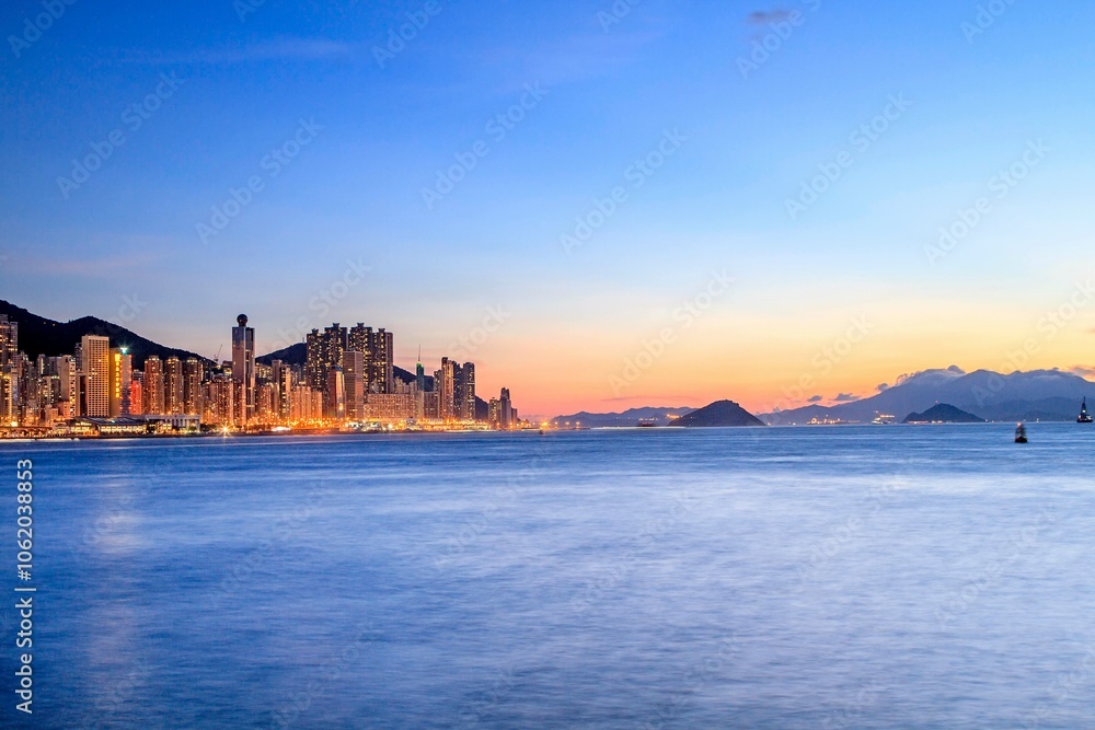 Fototapeta premium Vibrant Hong Kong City Skyline at Dusk by the Sea