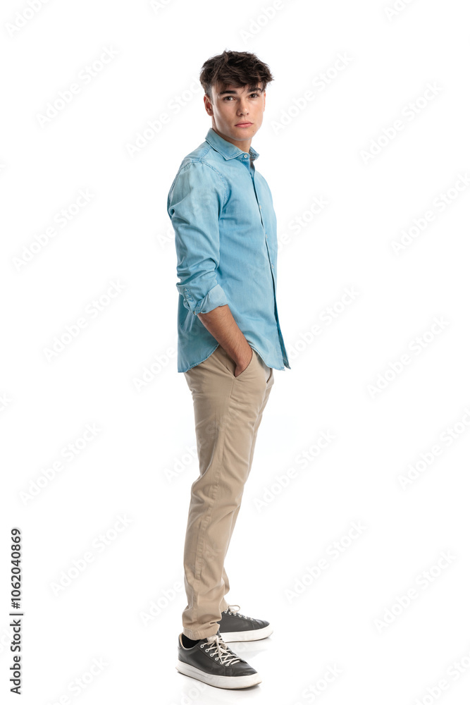 handsome young man standing in line with hands in pockets handsome young man standing in line with hands in pockets