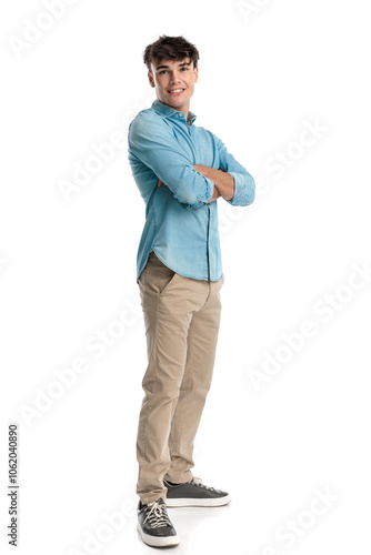 side view of proud young man crossing arms and smiling