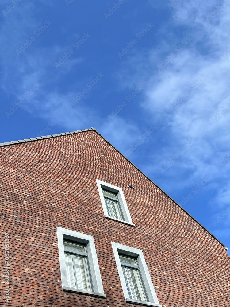 red brick building with white windows over sky red brick building with white windows over sky