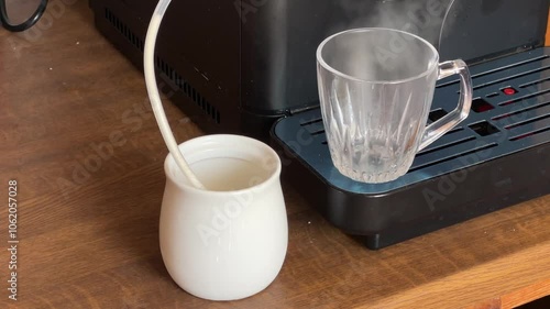 Pouring of hot frothed milk made with automatic coffee machine photo