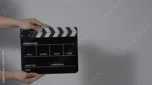 Movie slate or clapperboard hitting with recording frame. Close up hand holding empty film slate and clapping in front of camera clear background. Open and close film slate filming a video production