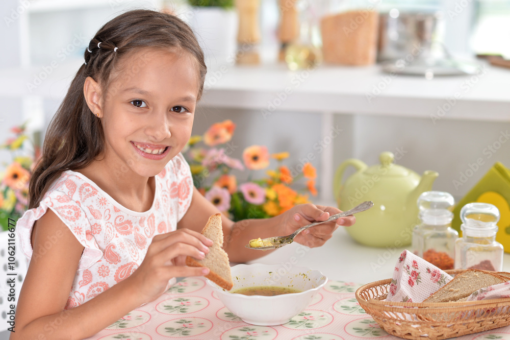 Little girl having breakfast in the kitchen at home Little girl having breakfast in the kitchen at home
