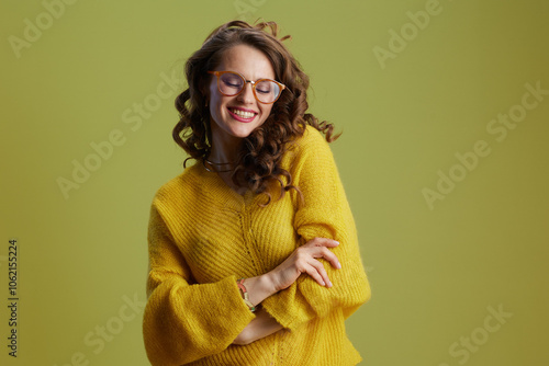 smiling healthy woman in sweater and glasses isolated on green