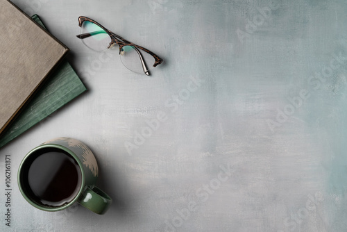 Book, glasses with mug of coffee on grey vintage background from above. Leisure concept, reading a book. Flat lay, top view. Copy space