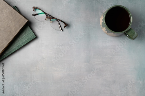 Book, glasses with mug of coffee on grey vintage background from above. Leisure concept, reading a book. Flat lay, top view. Copy space
