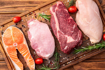 Mix of raw meat and fish . Salmon , beef , pork , chicken staek . Top view