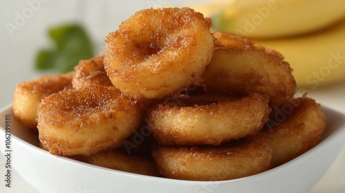 Crispy fried banana rings in a white bowl.